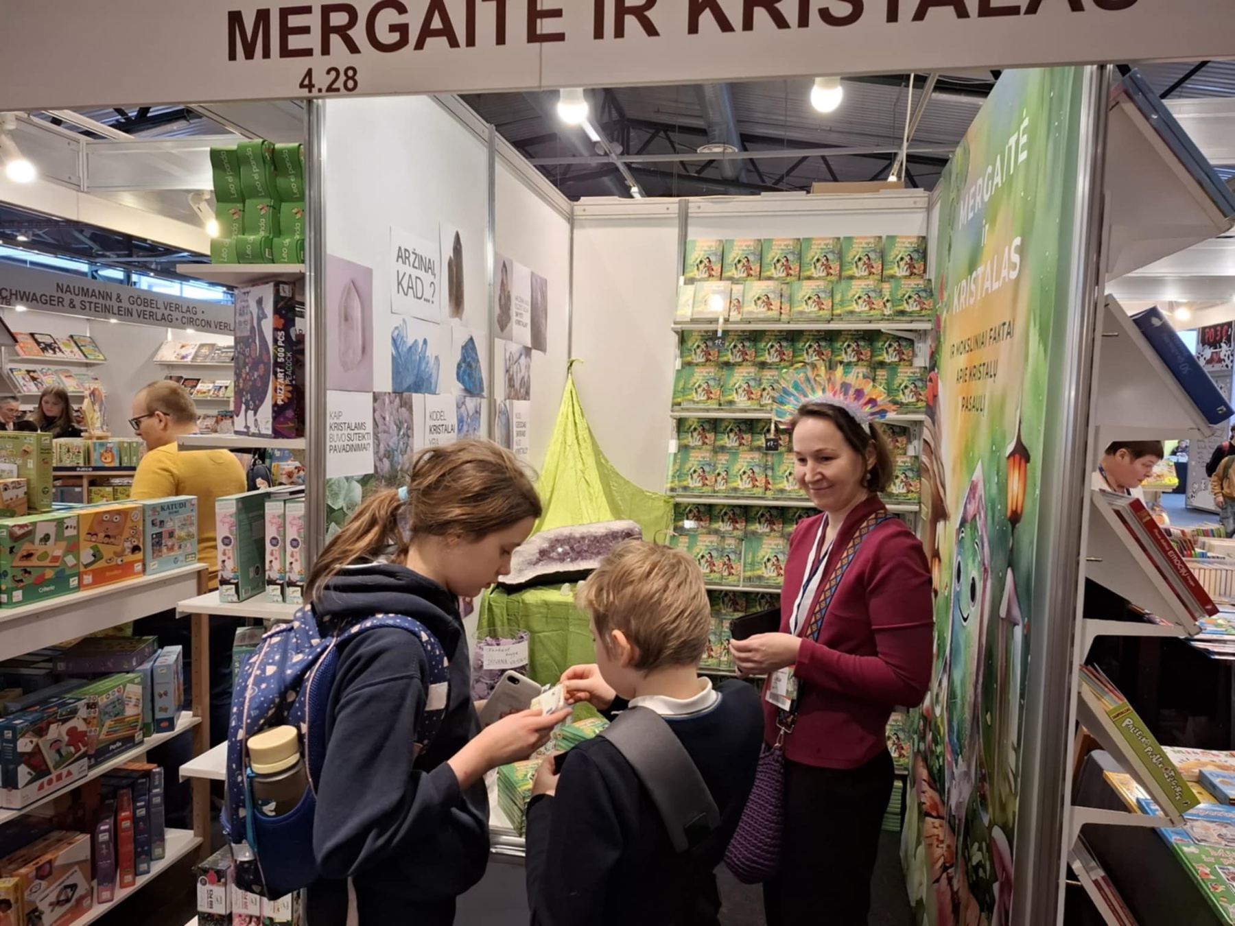 Jurga Nadin Luko su jaunaisiais skaitytojais prie knygos „Mergaitė ir Kristalas“ stendo Vilniaus knygų mugėje